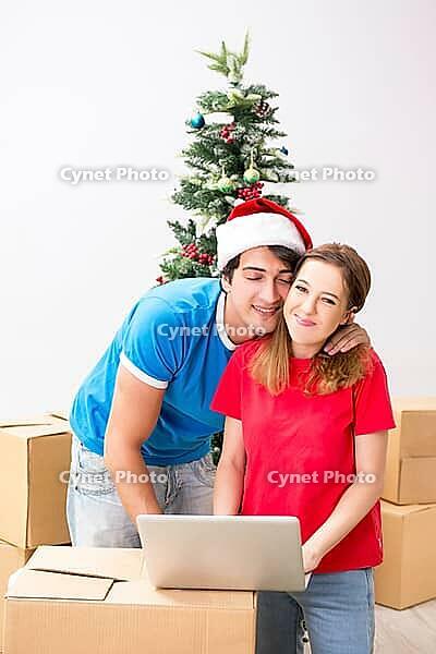 Young family celebrating christmas in new home [IBR125053219]