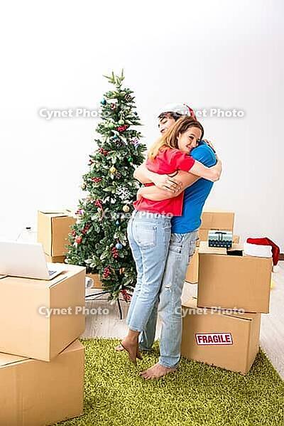 Young family celebrating christmas in new home [IBR125053220]