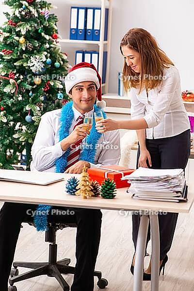 Colleagues celebrating christmas in office [IBR125053224]