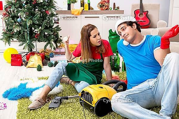 Young family cleaning apartment after christmas party [IBR125053230]