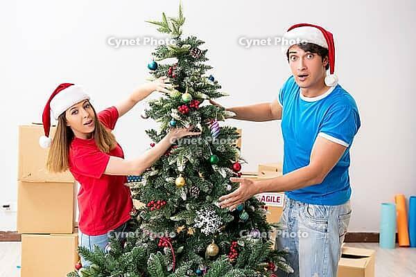 Young family celebrating christmas in new home [IBR125053232]