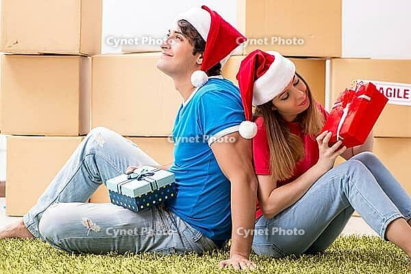 Young family celebrating christmas in new home [IBR125053233]