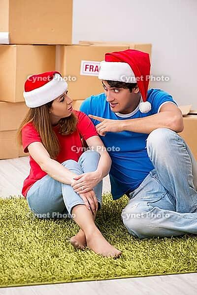 Young family celebrating christmas in new home [IBR125053234]