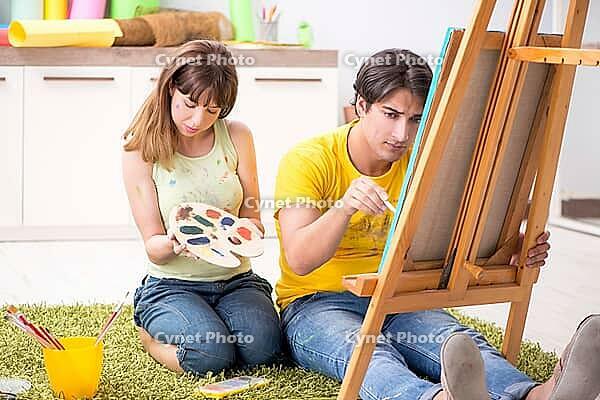 Young couple enjoying painting at home [IBR125053244]