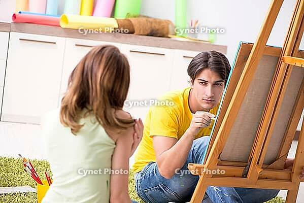 Young couple enjoying painting at home [IBR125053247]
