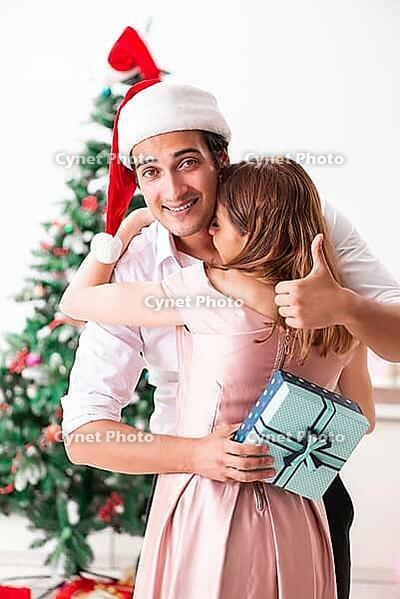 Young couple celebrating christmas at home [IBR125053251]