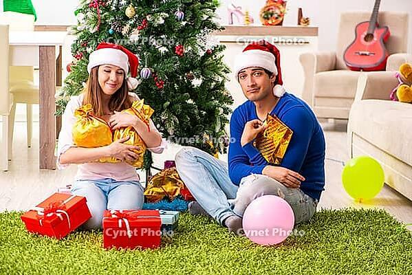 Young couple celebrating christmas at home [IBR125053258]