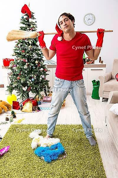 Man cleaning his apartment after christmas party [IBR125053261]