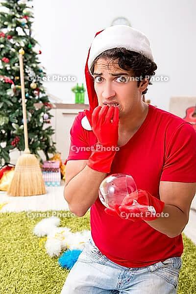 Man cleaning his apartment after christmas party [IBR125053263]