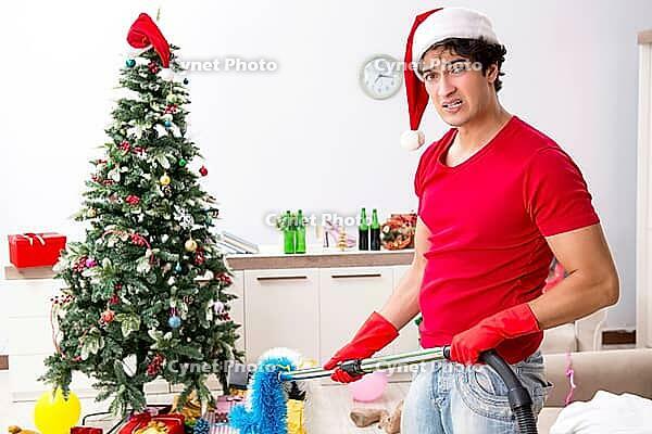 Man cleaning his apartment after christmas party [IBR125053264]