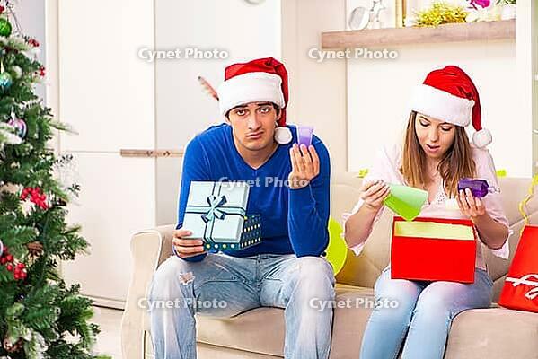 Young couple celebrating christmas at home [IBR125053265]