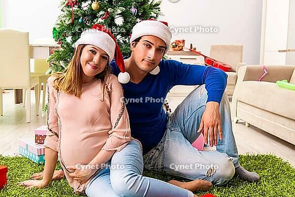 Pregnant wife celevrating christmas with husband [IBR125053267]