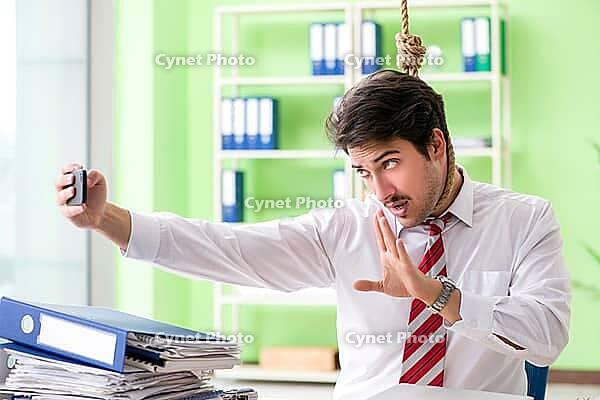 Despaired businessman thinking of suicide in the office [IBR125062166]
