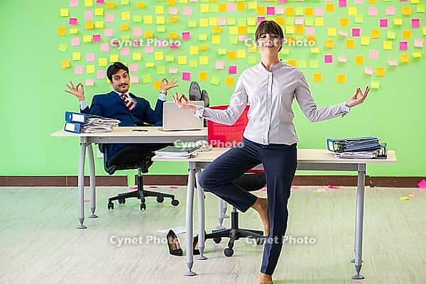 Man and woman in the office with many conflicting priorities in yoga concept [IBR125062178]