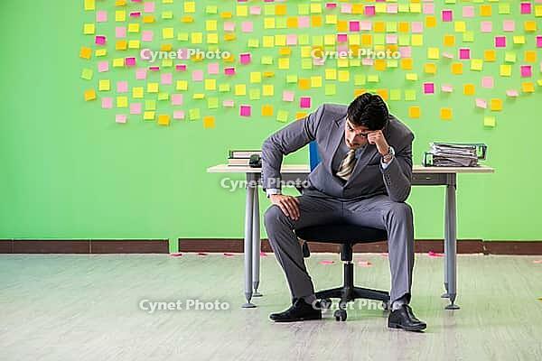 Businessman with many conflicting priorities [IBR125062192]