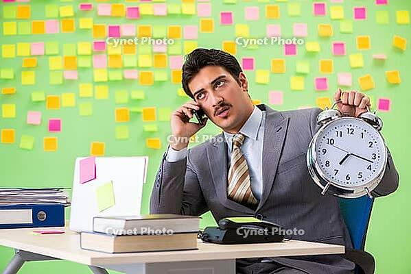 Businessman with many conflicting priorities in time management concept [IBR125062194]