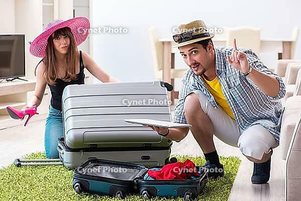 Young family packing for vacation travel [IBR125062213]