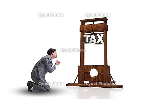 Businessman in heavy high taxes business concept [IBR125062224]