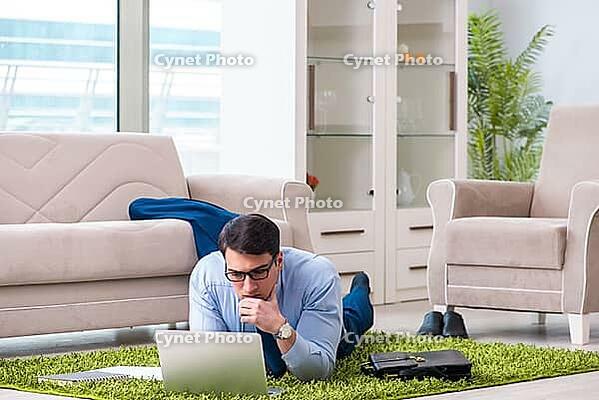Businessman taking work home and working overtime [IBR125062225]