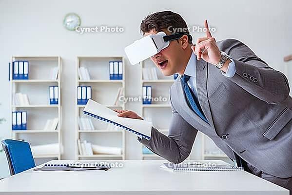Businessman with virtual reality glasses in the office [IBR125062227]