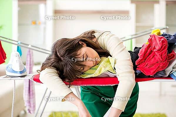 Young woman ironing clothing at home [IBR125062233]