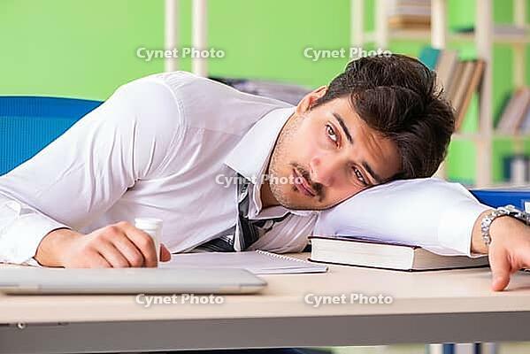 Sick and unhappy businessman sitting in the office [IBR125062253]