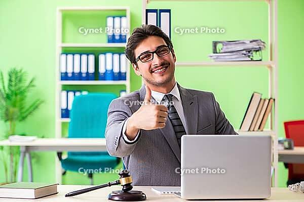 Young handsome lawyer working in the office [IBR125062254]