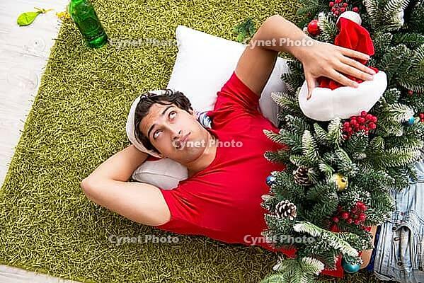 Young man drunk at home after christmas party [IBR125075734]