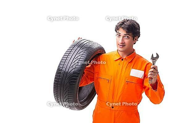 Young garage worker with tyre isolated on white [IBR125075746]