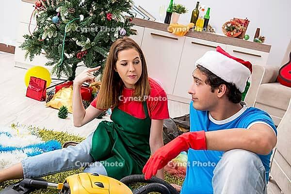 Young family cleaning apartment after christmas party [IBR125075763]