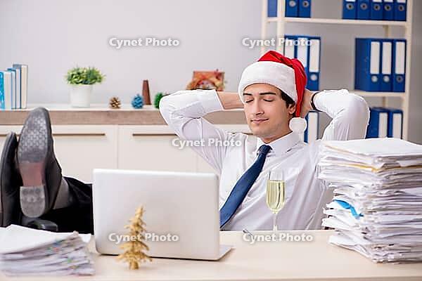 Young worker working in office on christmas shift [IBR125075773]