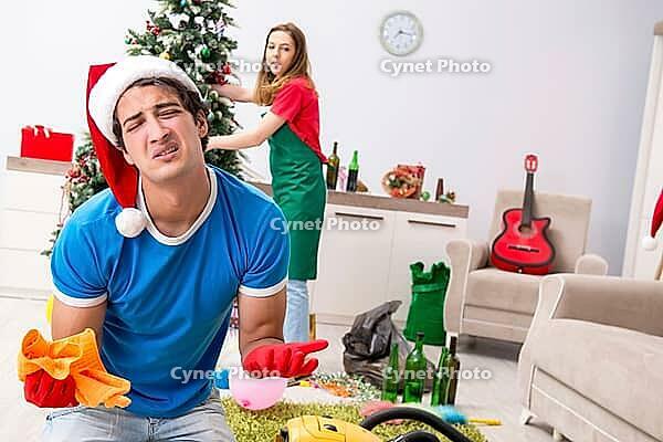 Young family cleaning apartment after christmas party [IBR125075776]
