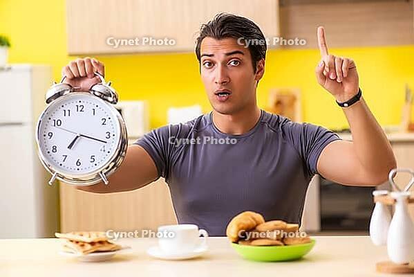 Young man in unhealthy food concept [IBR125075779]