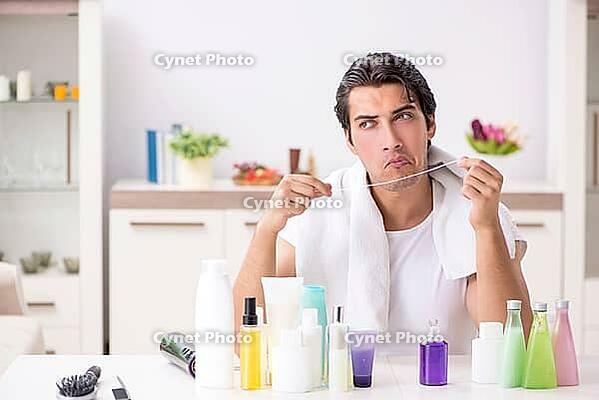 Young handsome man in the bathroom in hygiene concept [IBR125075791]