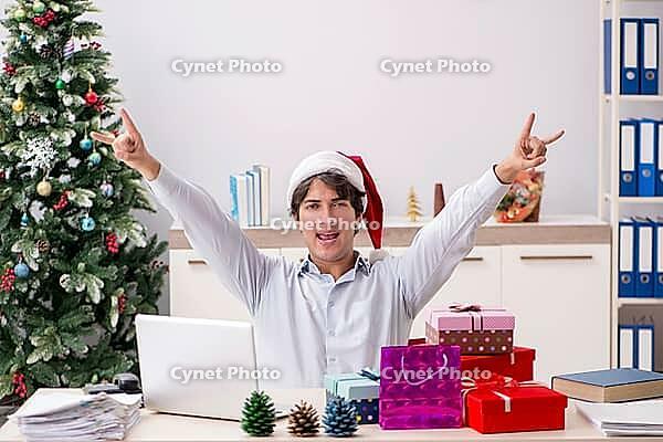 Young employee businessman in office christmas concept [IBR125075796]