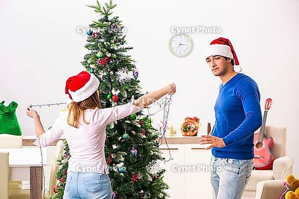 Young family celebrating christmas at home [IBR125075797]