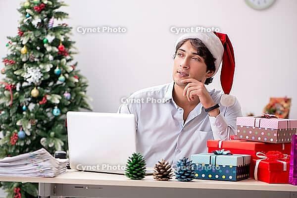 Young employee businessman in office christmas concept [IBR125075799]