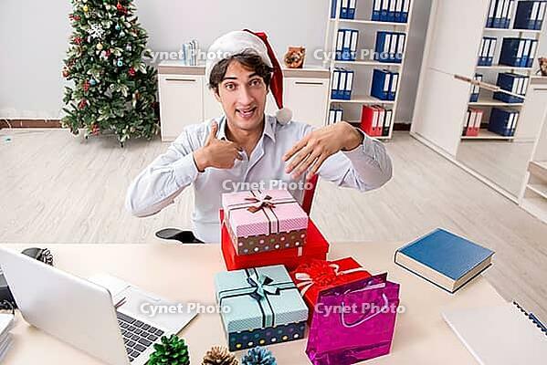 Young employee businessman in office christmas concept [IBR125075803]