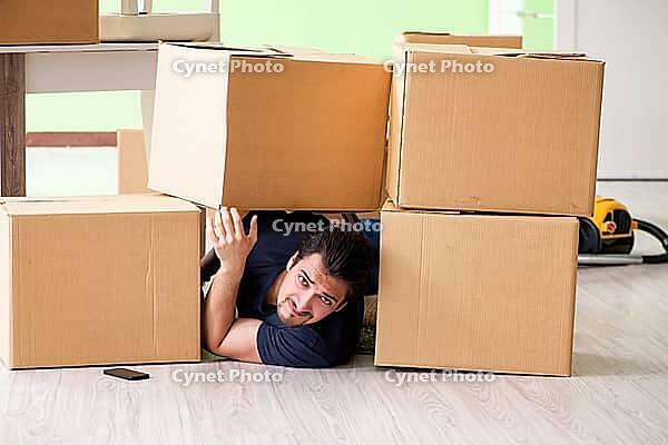 Man moving house with boxes [IBR125094355]