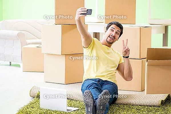Young handsome man moving in to new house with boxes [IBR125094359]