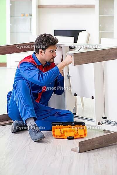 Repair contractor repairing broken furniture at home [IBR125094360]