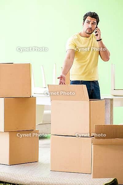 Young handsome man moving in to new house with boxes [IBR125094368]