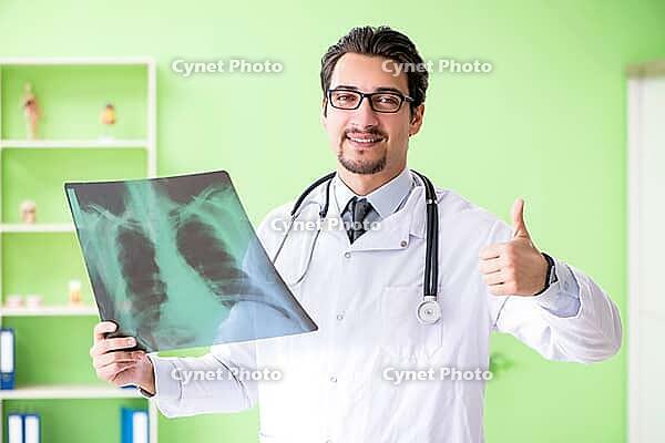 Doctor radiologist looking at x-ray scan in hospital [IBR125094371]