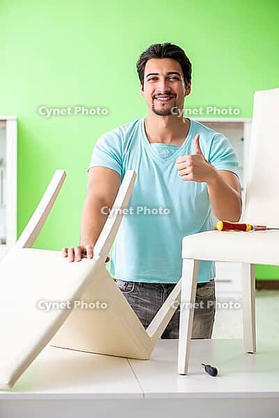 Man repairing furniture at home [IBR125094384]