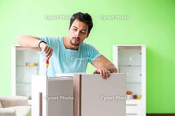 Man repairing furniture at home [IBR125094385]