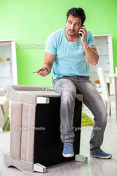 Man repairing furniture at home [IBR125094393]