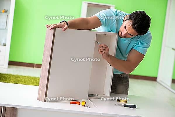 Man repairing furniture at home [IBR125094394]