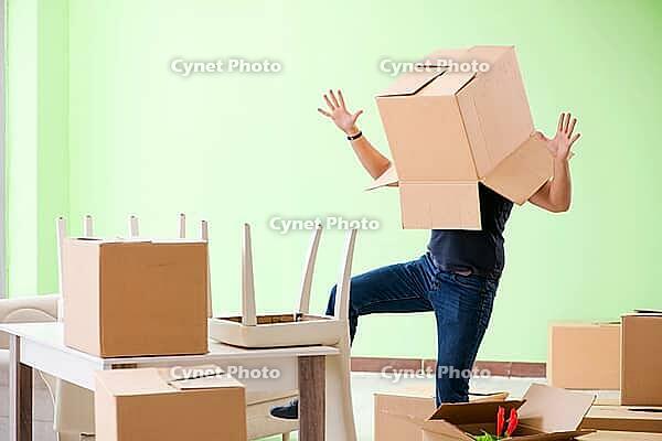 Man moving house with boxes [IBR125094395]