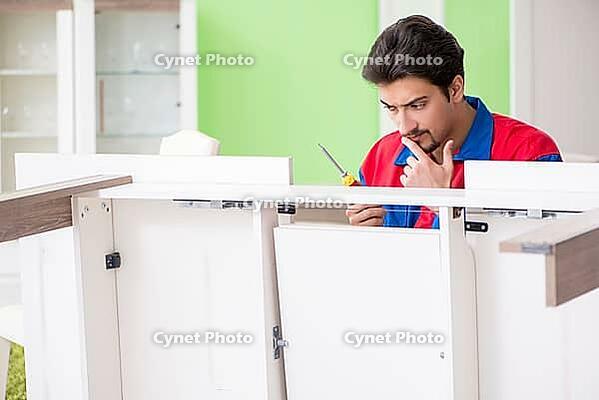 Repair contractor repairing broken furniture at home [IBR125094396]
