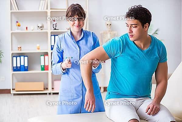 Doctor checking nerve reflexes with hammer [IBR125094403]